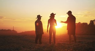 imagem de 3 pessoas em uma fazenda discutindo representando as relações contratuais entre tipos de produtores