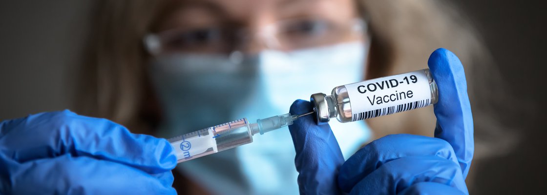 imagem de uma enfermeira com uma injeção na mão representando contrato de pessoas que não estejam vacinadas contra covid