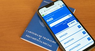 imagem de um celular em cima de uma carteira de trabalho representando recursos contra decisões sobre auxílio-doença