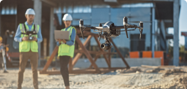 dois operarios numa construção civil utilizam drones e dispositivos móveis smart specs para inspeção da obra