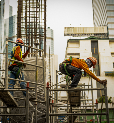 dois operários da construção civil trabalham com segurança em cima de andaimes com rede de proteção safetynet