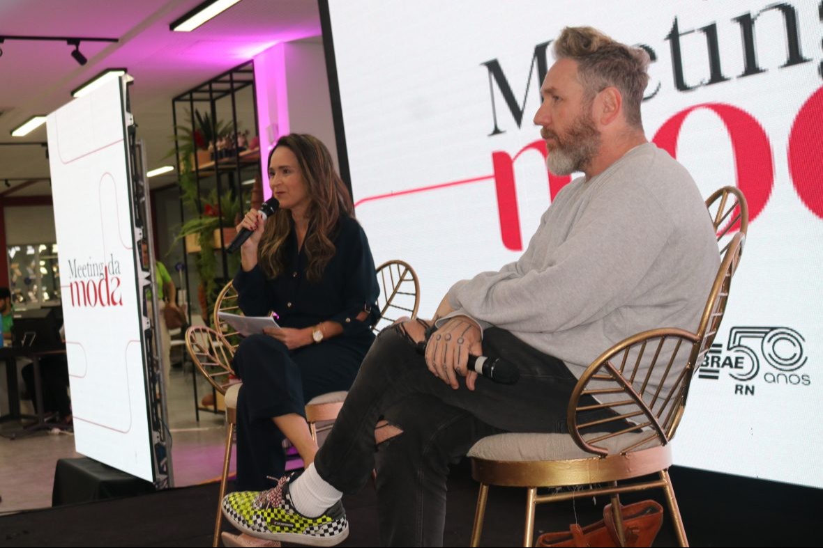foto: duas pessoas sentadas conversando em palestra, uma mulher e um homem branco