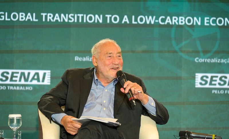 Foto: Gilberto Sousa/CNI senhor de camisa azul e blazer preto segura folhas e microfone sentado em uma cadeira