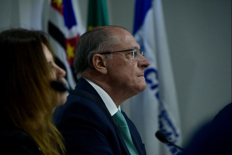 geraldo alckmin, vice presidente da República, é um homem branco, usa óculos de grau, terno escuro, camisa branca e está de perfil em foto colorida
