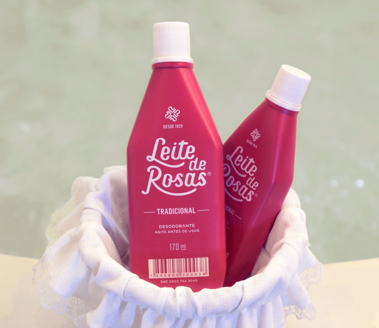 Duas embalagens de desodorante Leite de Rosas cor de rosa com tampas brancas