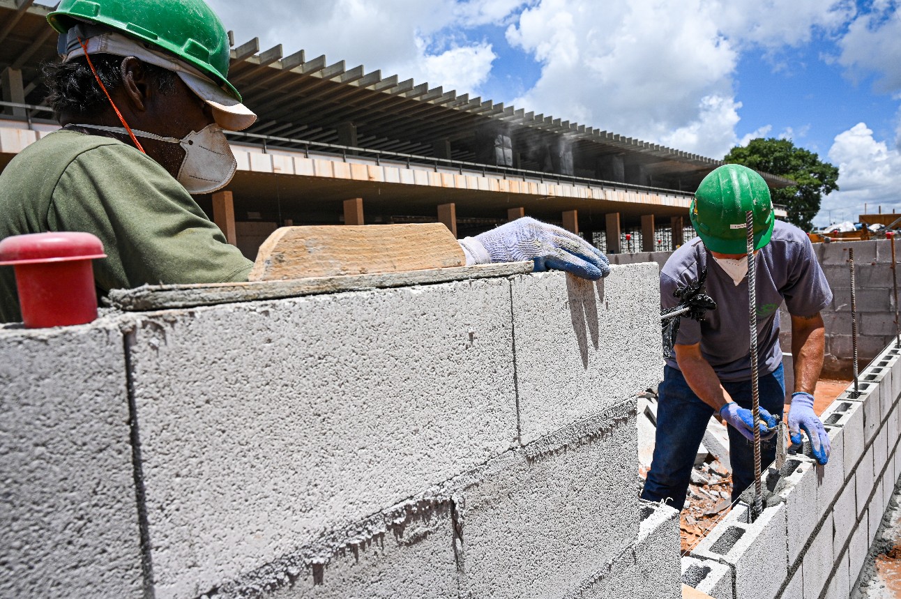 Trabalhador da construção civil utilizando cimento