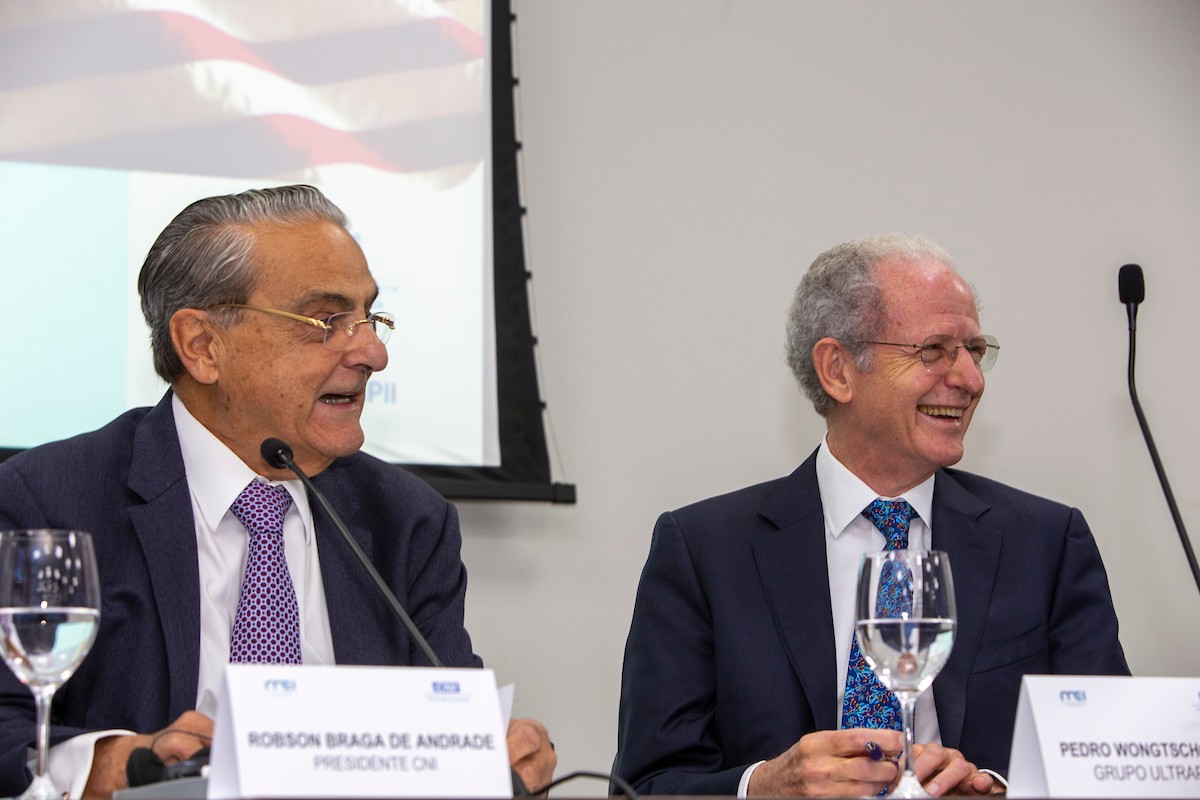 Presidente da CNI, Robson Braga de Andrade, à esquerda, é um homem branco, de cabelos brancos e óculos. Na foto, está acompanhado de Pedro Wongtchoswki, também branco e mais velho. Ambos usam óculos.