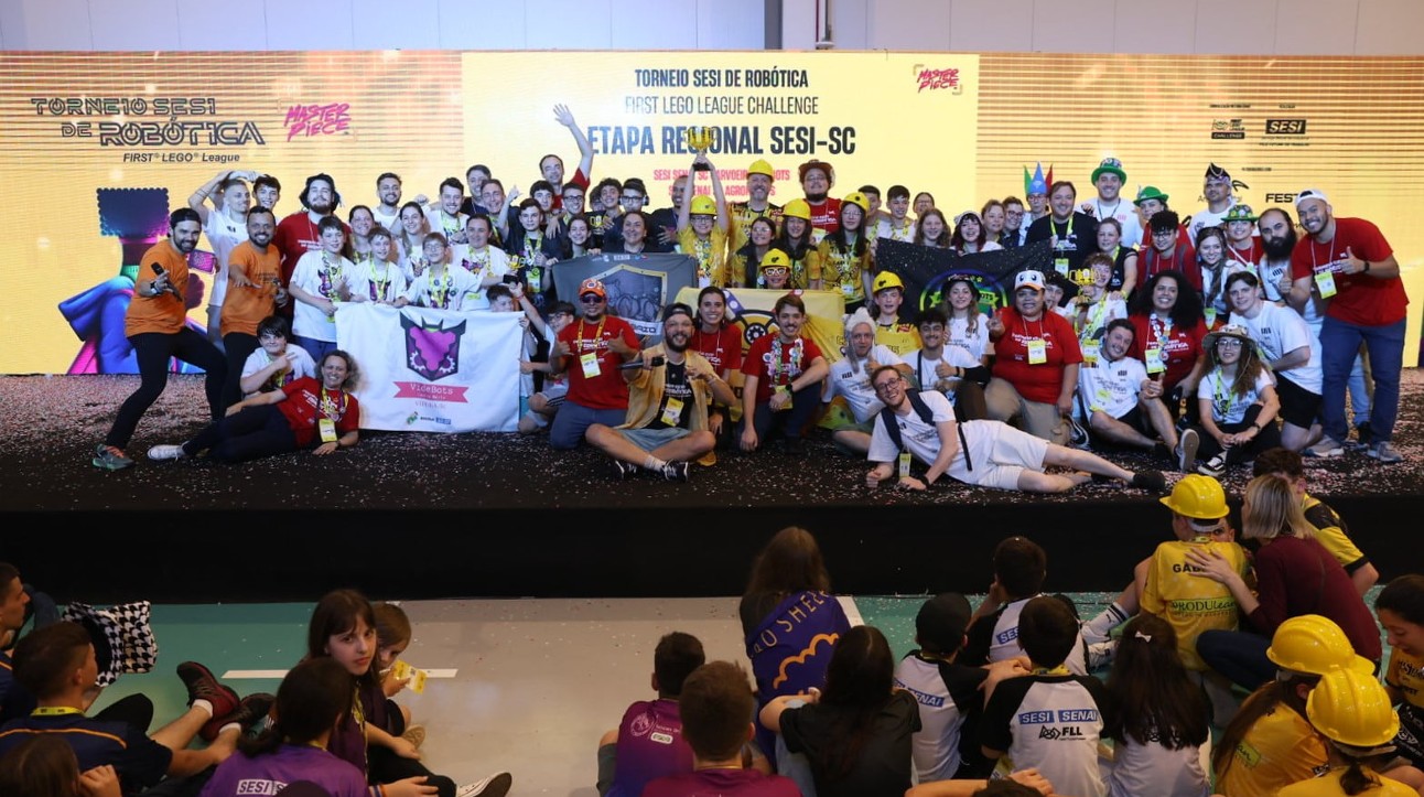 Diversas pessoas em cima do palco com bandeira