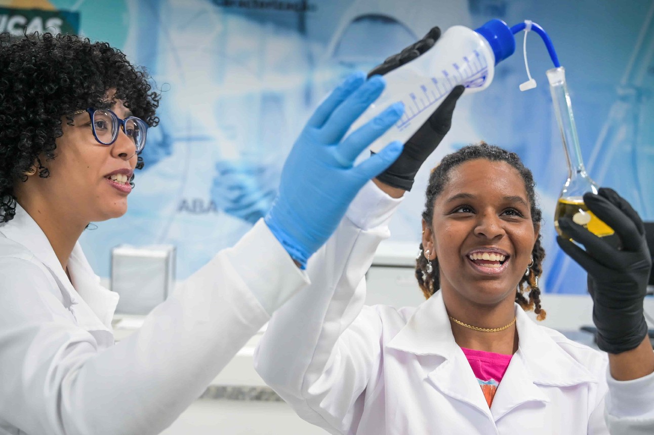 Mulheres pretas cientistas em laboratório mexem com compostos quimícos