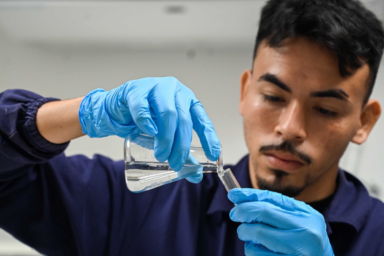 Homem passando líquido de um frasco para outro