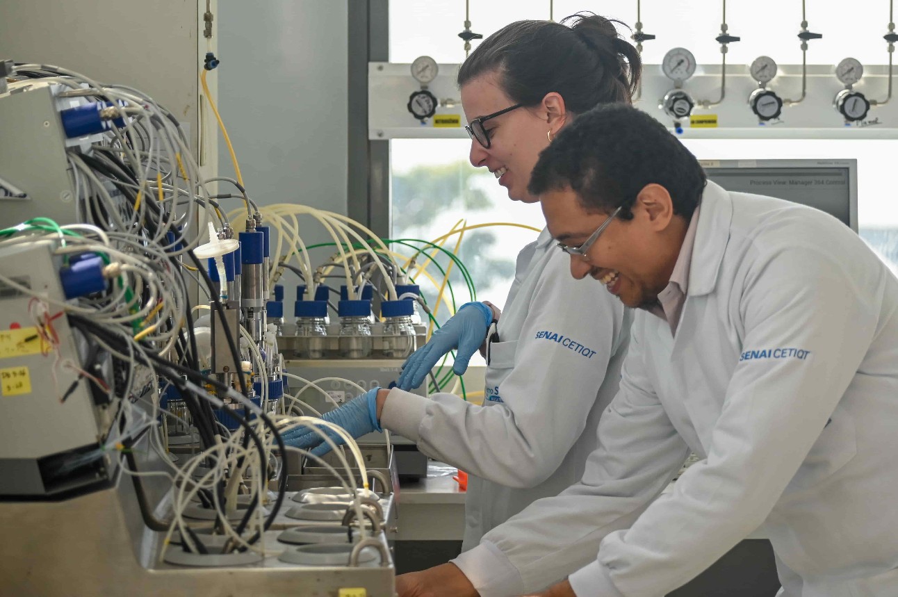 dois pesquisadores sorriem enquanto trabalham em um laboratório