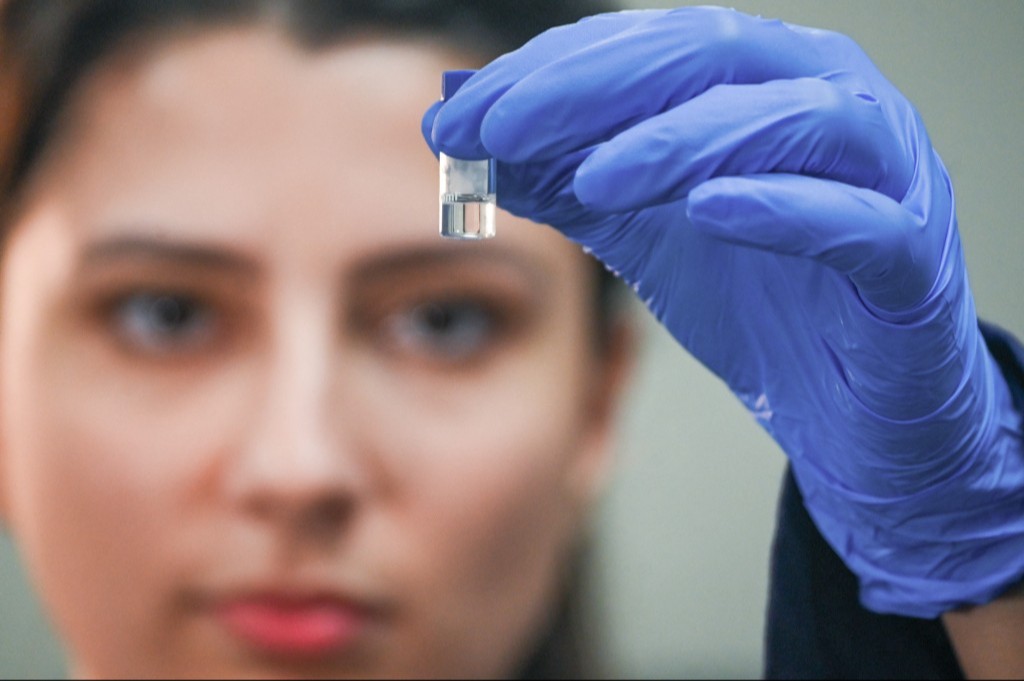 Cientista olhando pequeno frasco