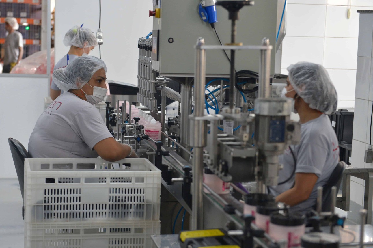 imagem colorida de mulheres com EPIs, trabalhando em fábrica, com equipamentos de fábrica