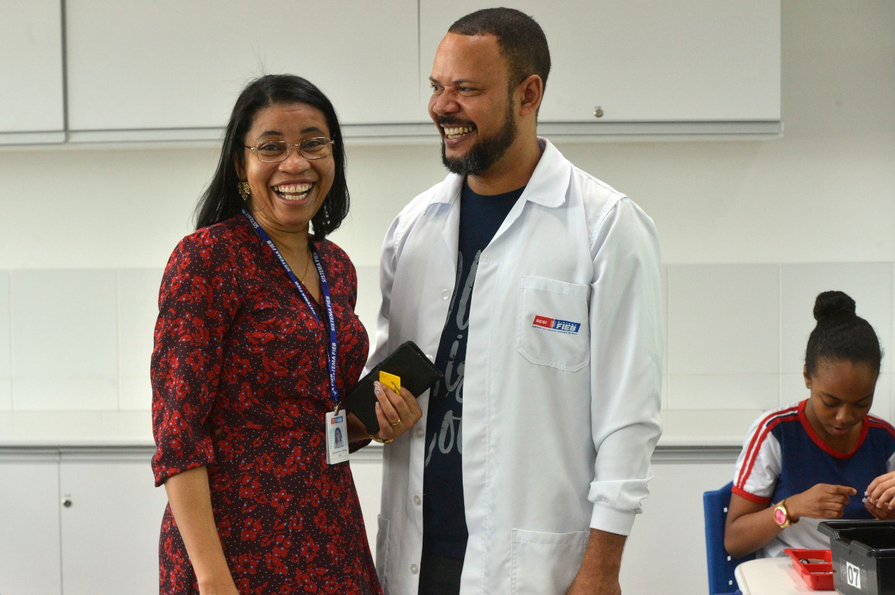 Dois professores sorrindo dentro de uma sala de aula