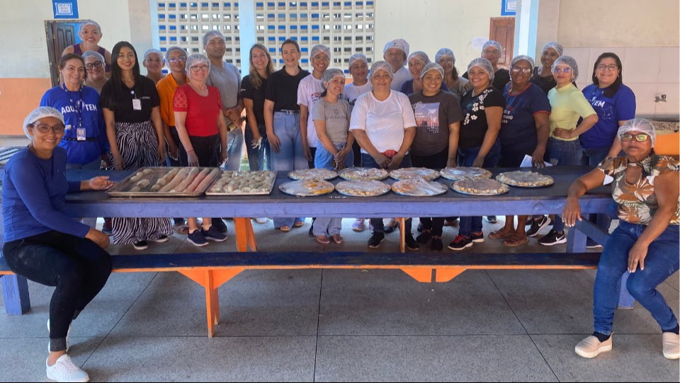 grupo de mulheres posam juntas em frente a mesa