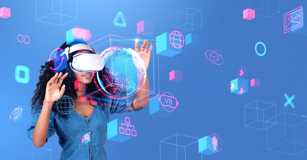 Retrato de uma bela jovem afro-americana com óculos de realidade virtual (RV) explorando o metaverso sobre fundo azul. Conceito de realidade virtual, educação e ciberespaço