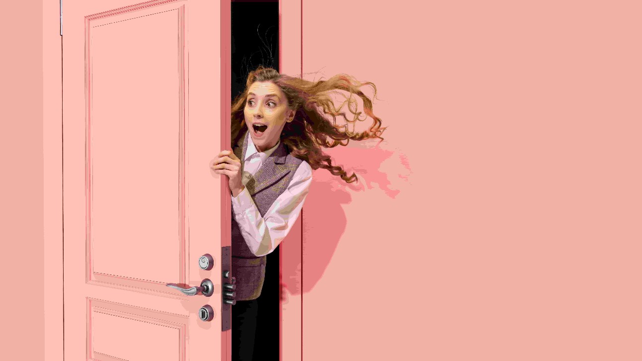 Menina bonita espreitando pela porta rosa aberta e olhando com entusiasmo positivo, espanto. Olhar surpreso. Boas notícias, vendas. Conceito de emoções, faciais