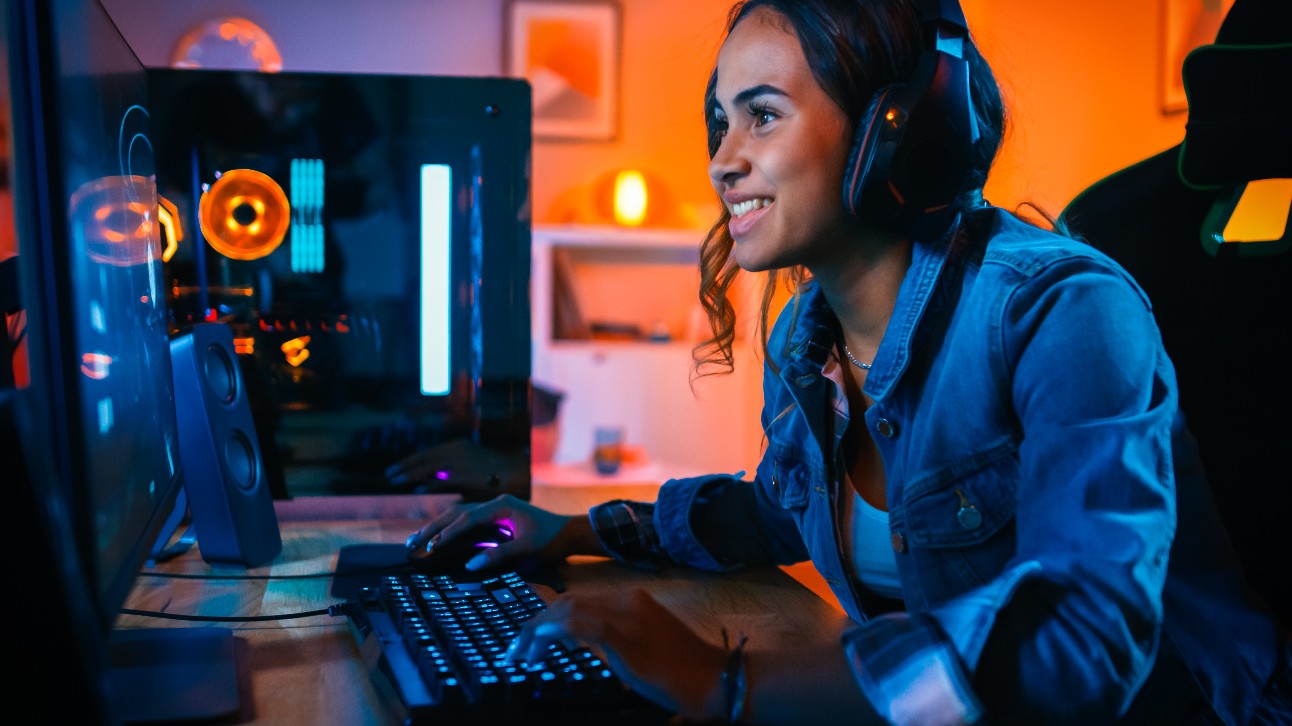 Garota negra com fones de ouvido em primeira pessoa no computador dela. O quarto e o PC têm luzes LED coloridas de néon