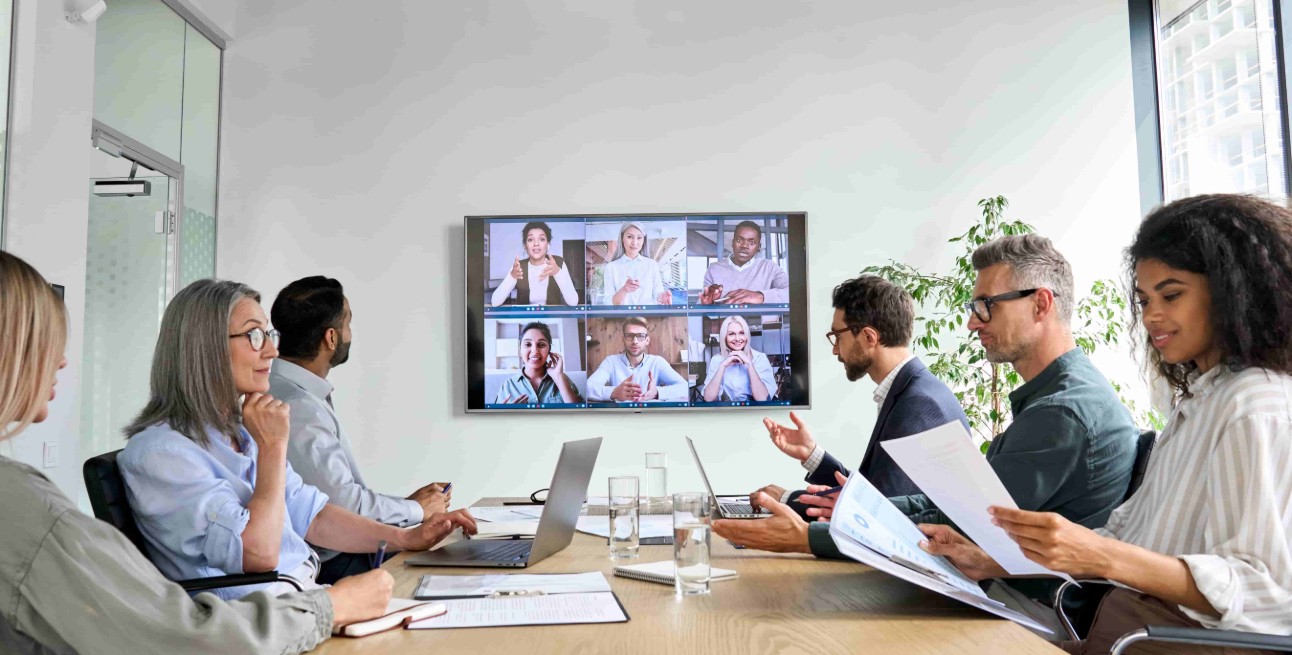 Diversos funcionários da empresa com videochamada de conferência de negócios on-line no monitor da tela da TV na sala de reuniões do conselho. Apresentação por videoconferência, conceito de treinamento corporativo de grupo virtual global.