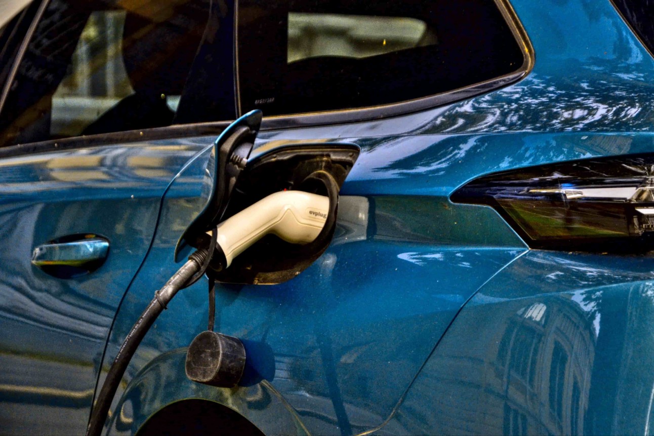 Saint-Etienne, França - 1 de setembro de 2024 : Blue Peugeot 308 III (desde 2021) encarregado na rua de um terminal público de carregamento. É a versão híbrida deste carro.