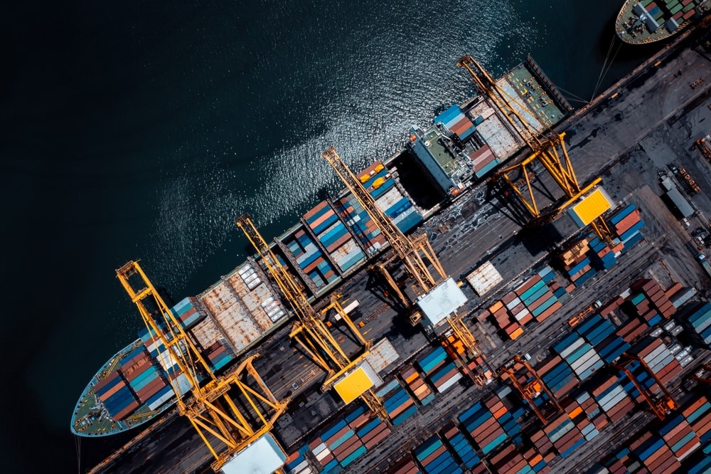 porto comercial em carga de mar negro, descarga de carga de porta-contentores importação exportação por grua para distribuição de mercadorias por reboques transporte logística para clientes e concessionários, processo de tom cinemático,