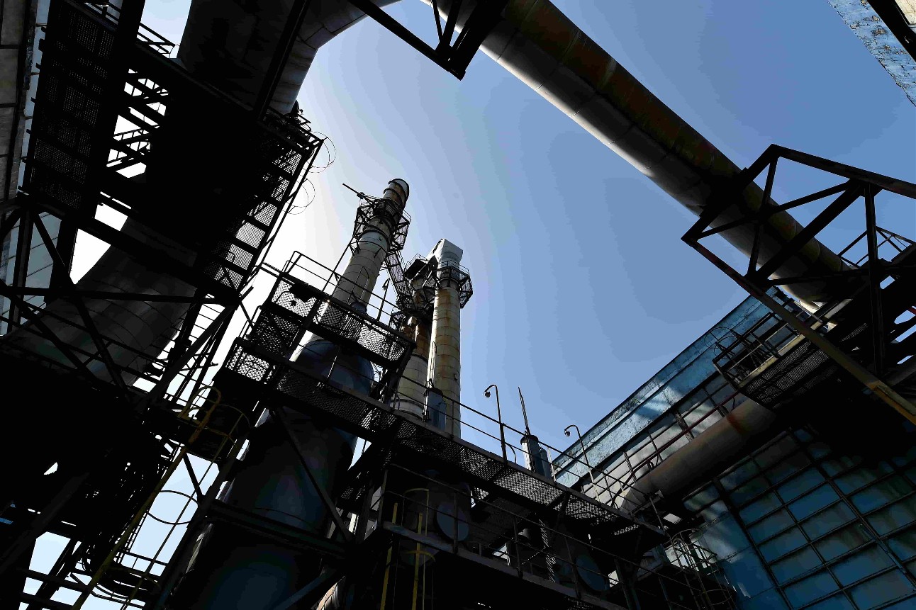 Estrutura metálica de indústria e céu azul ao fundo