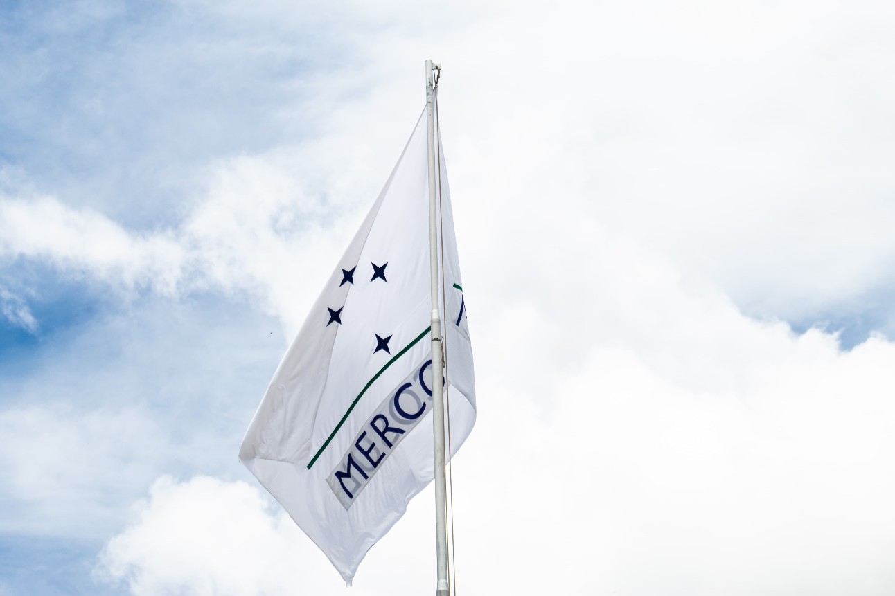 Bandeira do Mercosul com fundo de céu com nuvens brancas