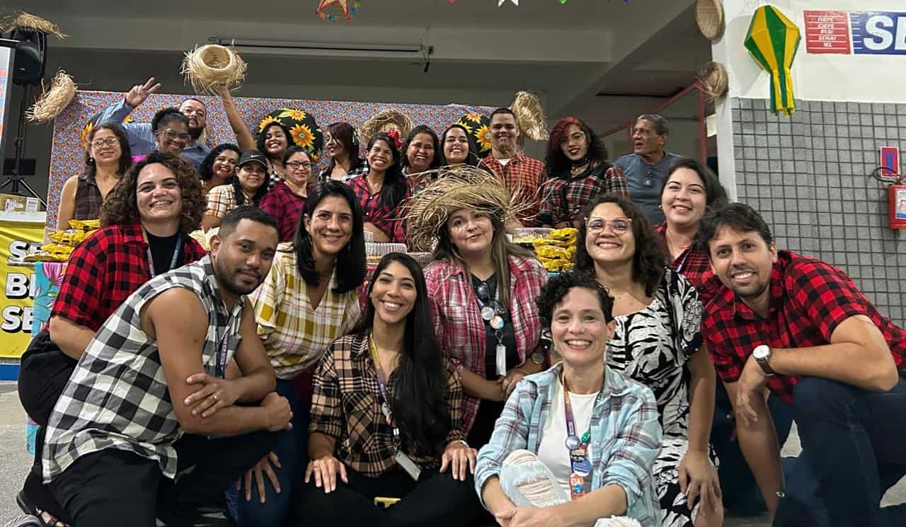 Grupo de mais de 20 pessoas usando camisas xadrez e chapéus de palha