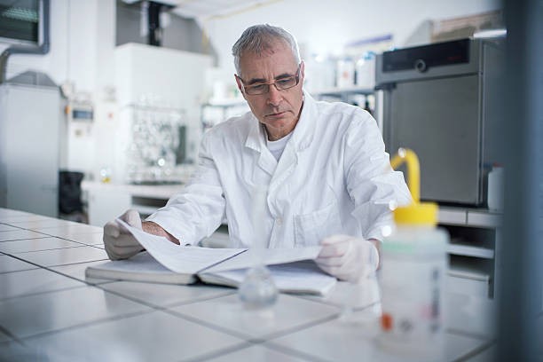 Homem usando um jaleco branco, sentado em um laboratório
