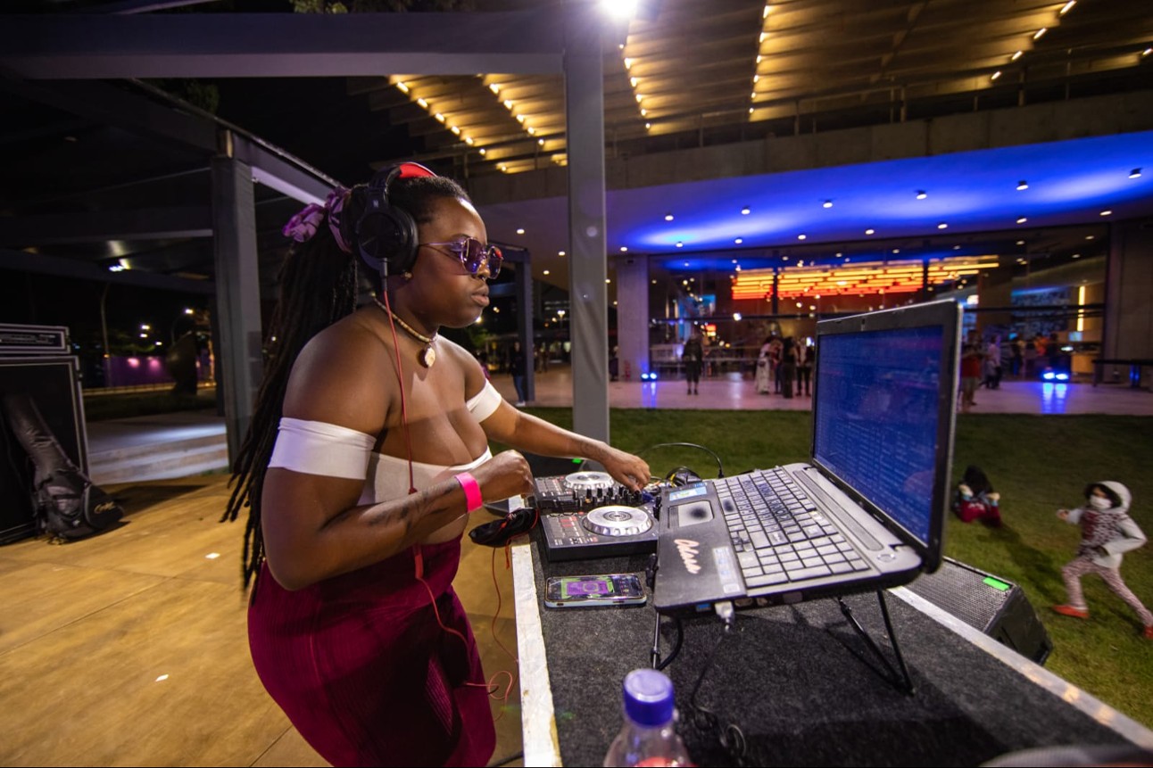 Mulher negra mexe em equipamentos de DJ