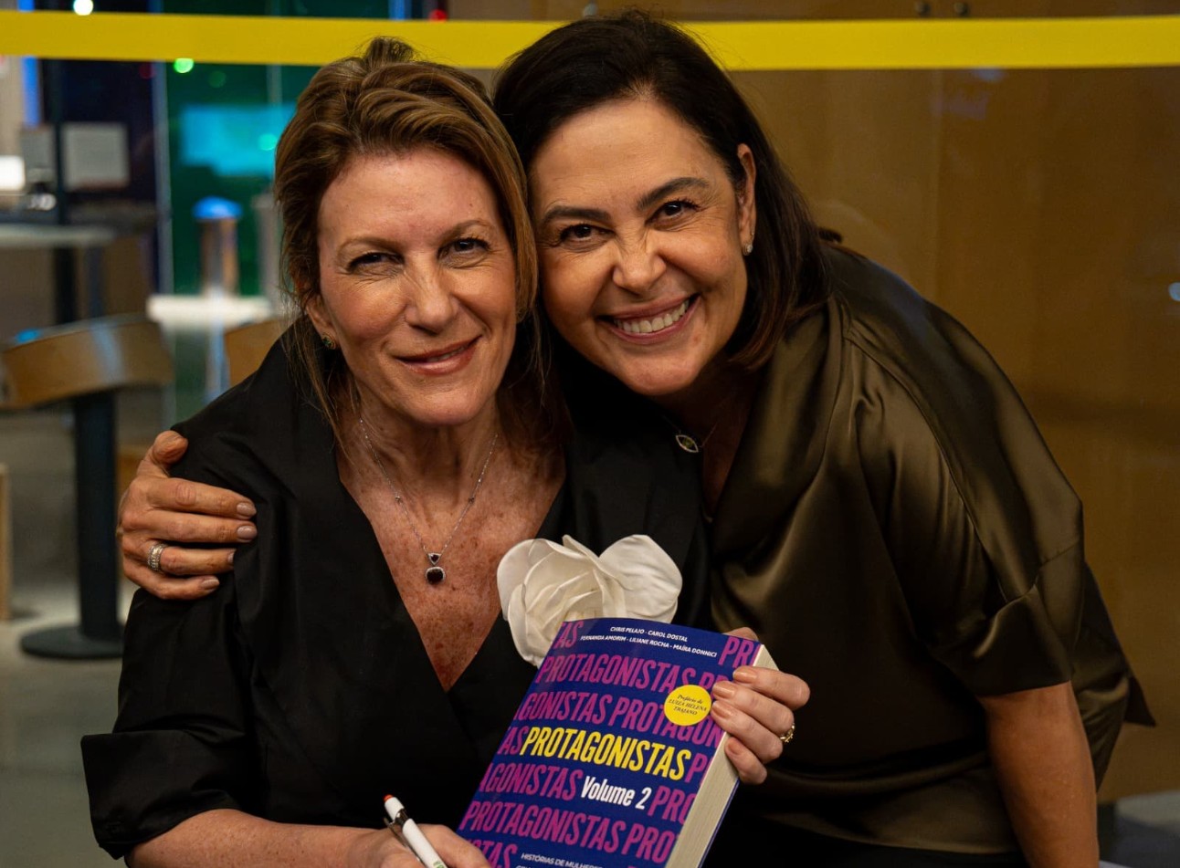 Mônica Monteiro, presidente do Fórum Nacional da Mulher Empresária, à esquerda, e Claudia Ramalho, superintendente de Cultura do SESI, à direita, durante o Entre Páginas, no SESI Lab