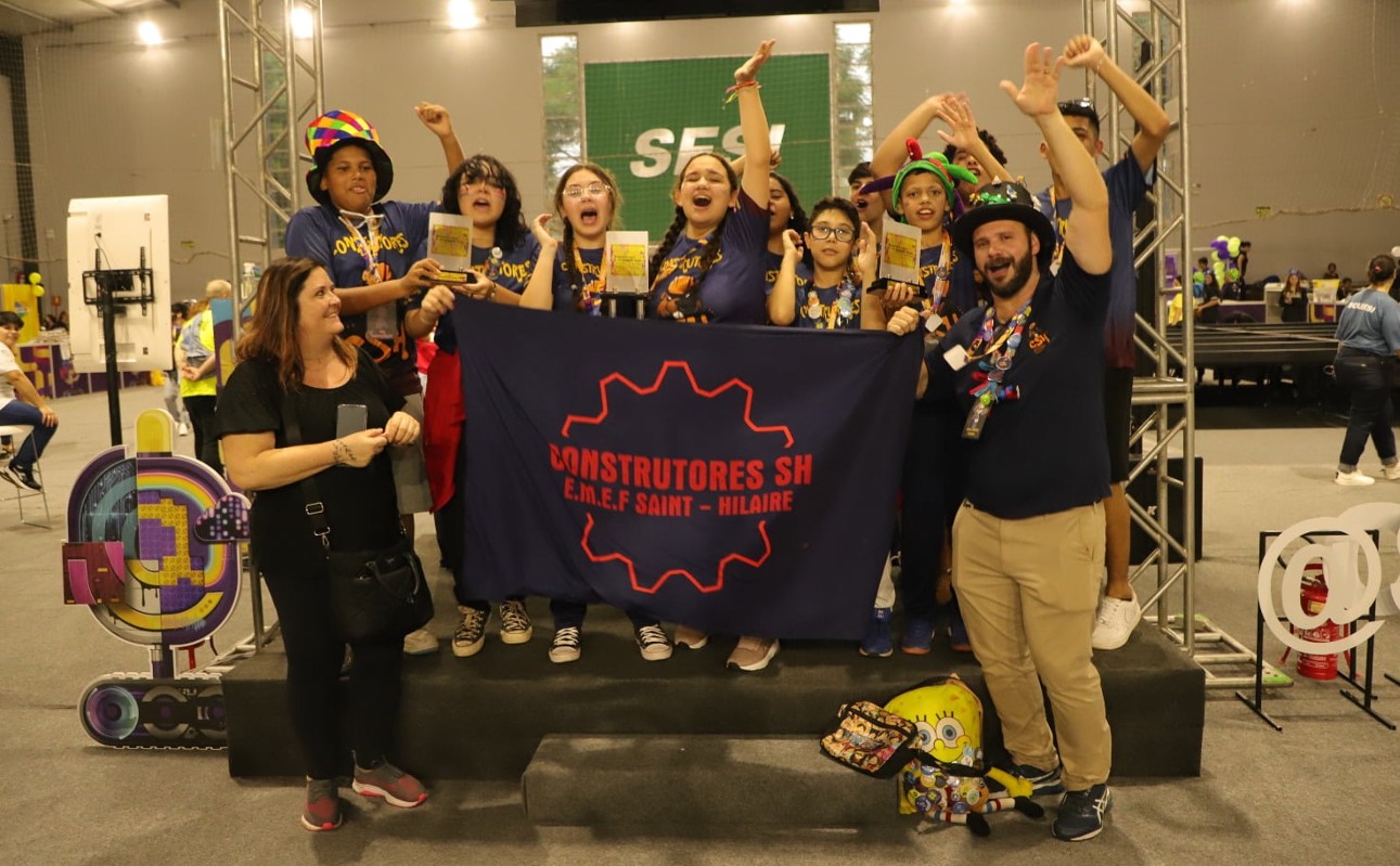 Jovens seguram bandeira azul em gestos de comemoração em ambiente de competição